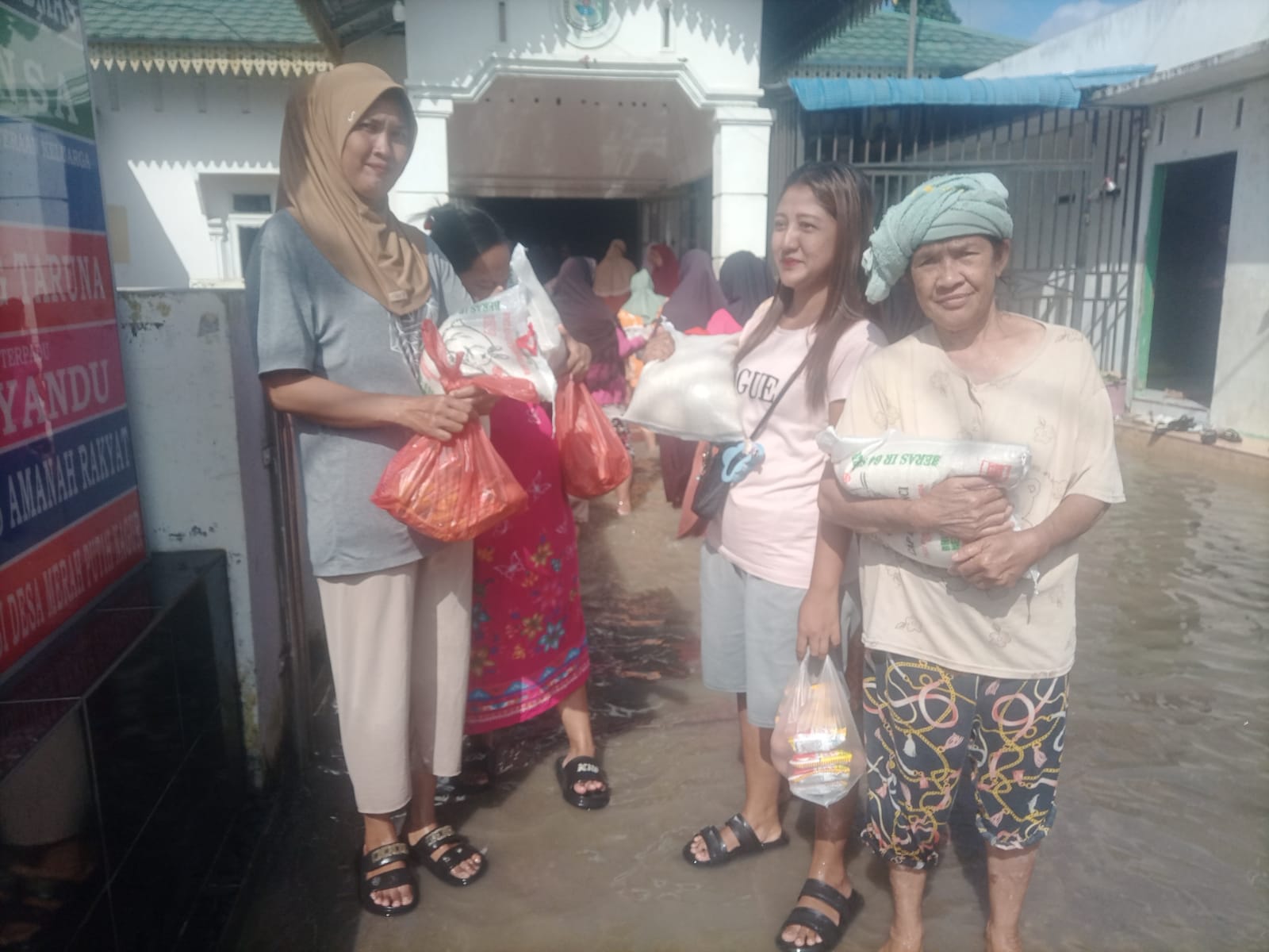 Warga Desa Nagur menerima bantuan beras dan paket sembako yang disalurkan Pemdes Nagur kepada masyarakat terdampak banjir. ( Fadly/Sumut Pos)