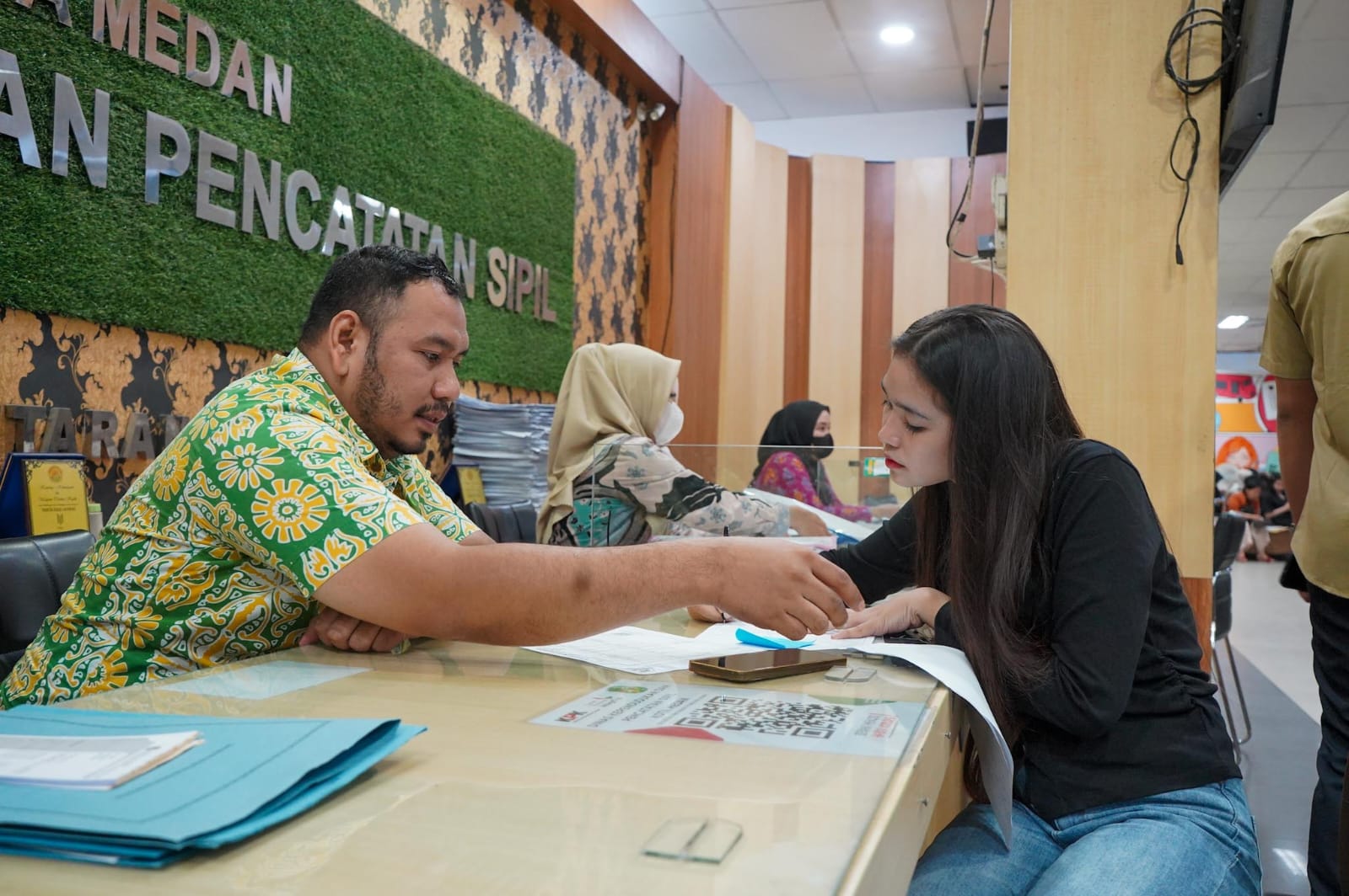 LAYANI: Pegawai Disdukcapil Medan saat melayani warga yang mengurus dokumen. (Dok: Pemko Medan)