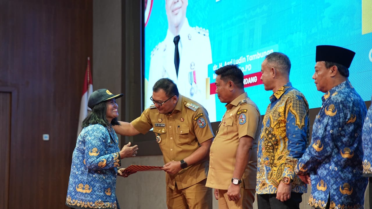Bupati Deliserdang dr Asri Ludin Tambunan didampingi Wakil Bupati, Lom Lom Suwondo SS  menyerahkan SK PPPK kepada dua orang perwakilan dari 800 tenaga honor diangkat di Graha Bhineka Perkasa Jaya.