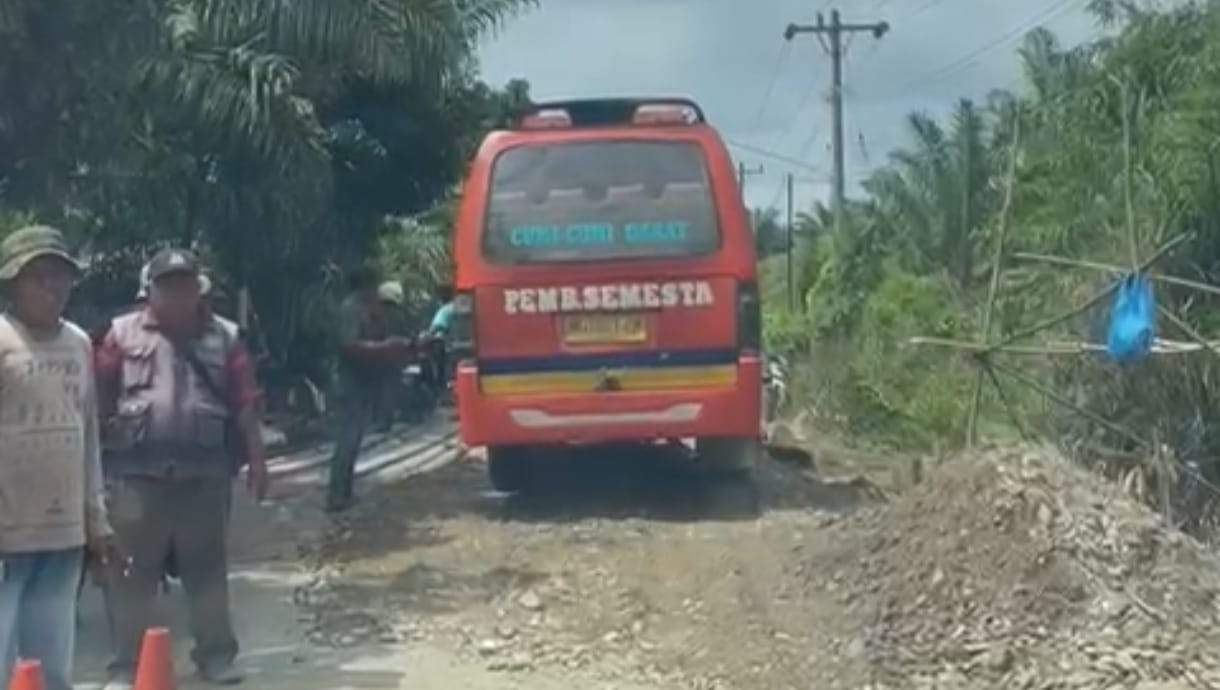 Angkutan umum melintas di Jalan Lintas Padangtualang-Batangserangan melalui Tanjung Beringin, pada titik yang amblas pascamusibah banjir di Langkat.(Istimewa/Sumut Pos)