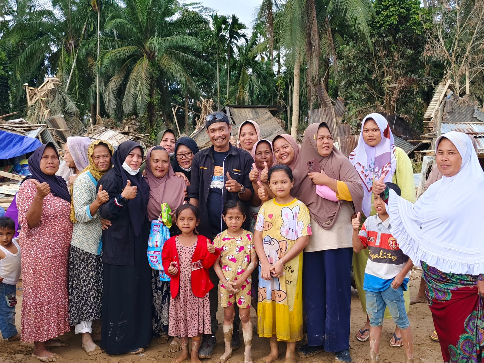 Para relawan dari komunitas KOLAC, Sahabat Yatim & Dhuafa, Kami Anak Tebing Tinggi, dan Isyarah berfoto bersama warga Desa Babo, Kecamatan Bandar Pusaka,  Aceh Tamiang. (Azan Purba/ Sumut Pos)