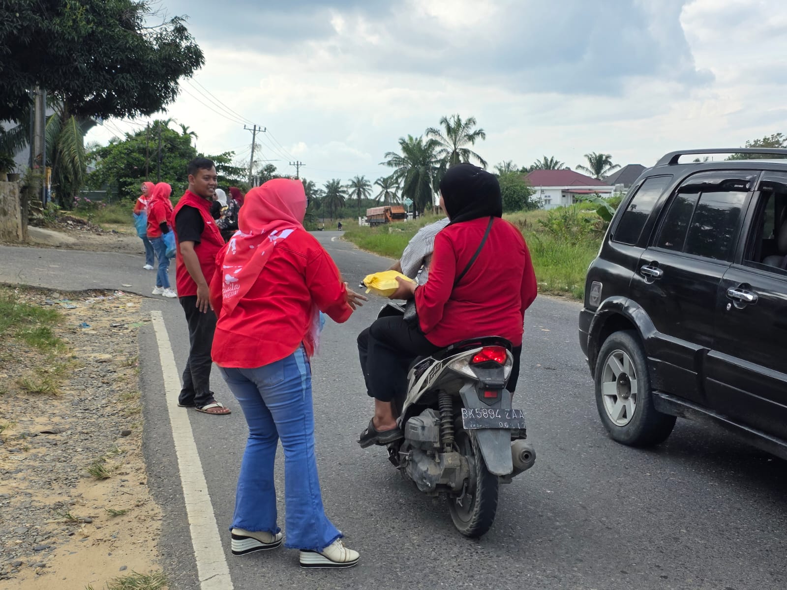 Kader PDIP Perjuangan Labusel membagikan nasi bungkus kepada masyarakat pengendara sepeda motor. (KHAIRUDDIN/SUMUT POS)