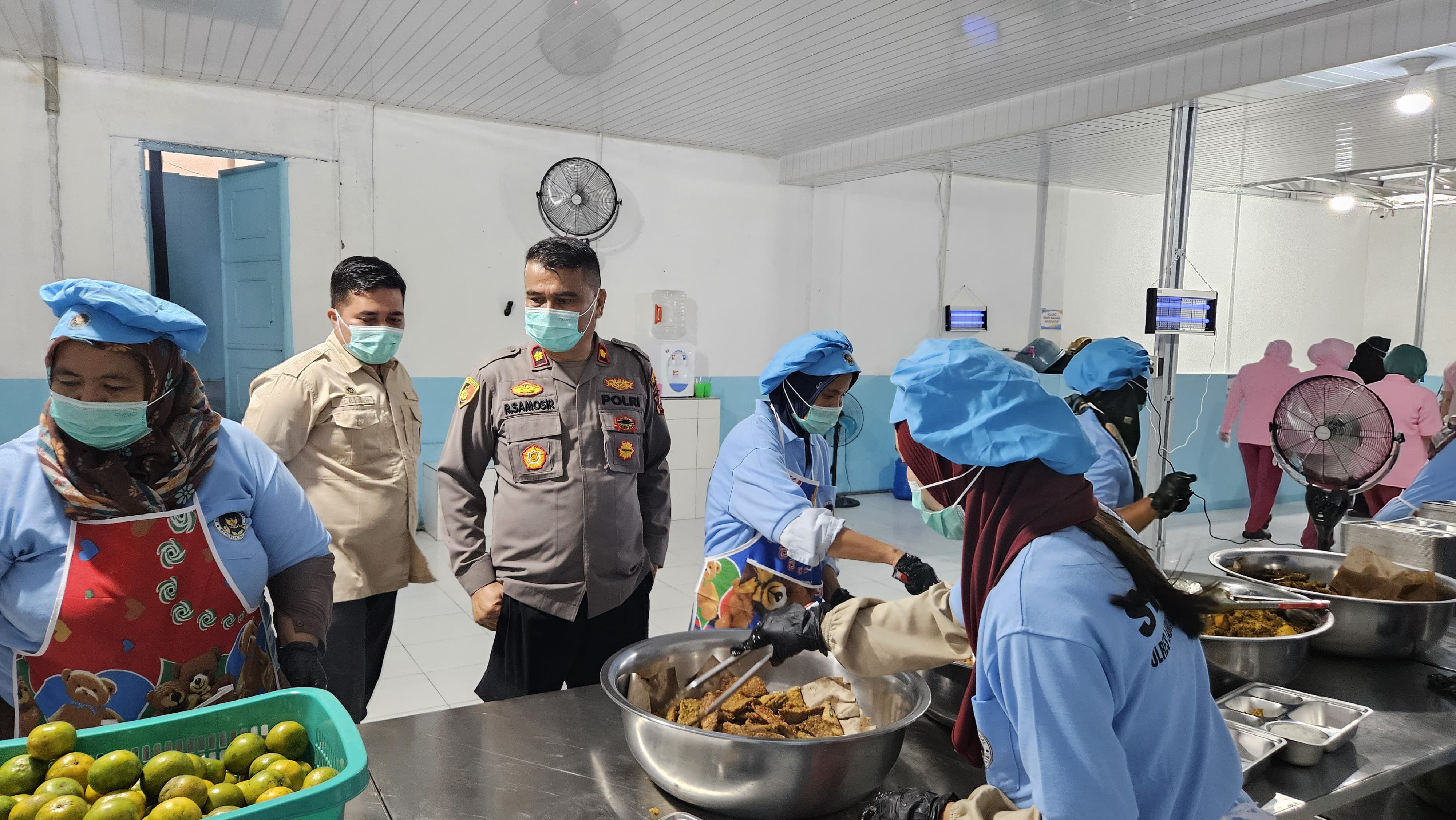 Wakapolres Labuhanbatu Selatan, Kompol Ramsen Samosir, S.H., M.H. memeriksa kebersihan para pegawai SPPG sebelum makanan dibagikan. (ISTIMEWA/SUMUT POS)