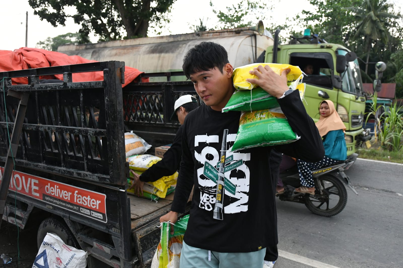 BANTUAN: Kapten tim PSMS Kim Jeung Ho membagikan bantuan kepada warga terdampak bencana di Tanjungpura, Langkat, Jumat (12/12/2025). (Dok: PSMS)