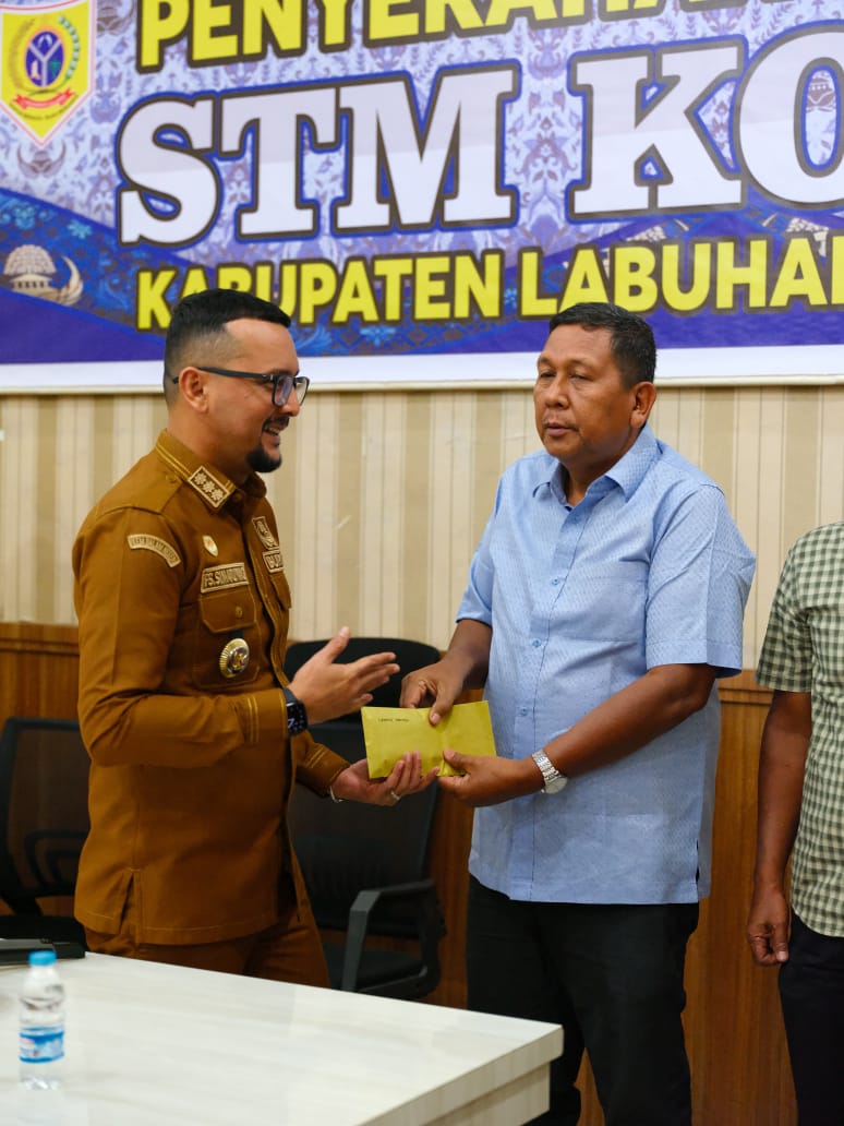 Bupati Labuhanbatu Selatan, Fery Sahputra Simatupang, menyerahkan santunan kepada ASN dan ASN Purna Tugas. (KHAIRUDDIN/SUMUT POS)