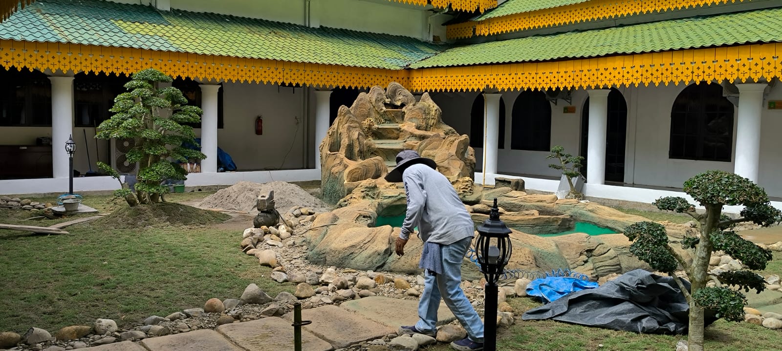 Pekerja saat bekerja membuat taman dalam di depan ruang fraksi pada Sekretariat DPRD Langkat, Stabat. (Teddy Akbari/Sumut Pos)