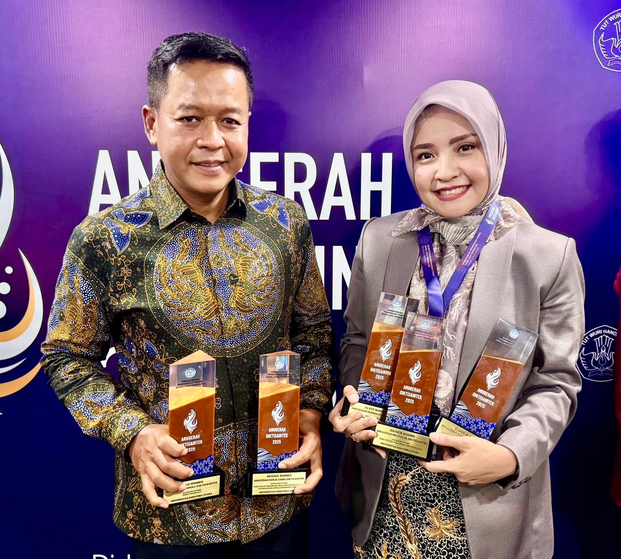 TUNJUKKAN: Rektor USU Prof Muryanto Amin dan Kepala Humas, Protokoler, dan Layanan Terpadu USU Amalia Meutia, tunjukkan trofi yang diraih pada Anugerah Diktisaintek 2025.
