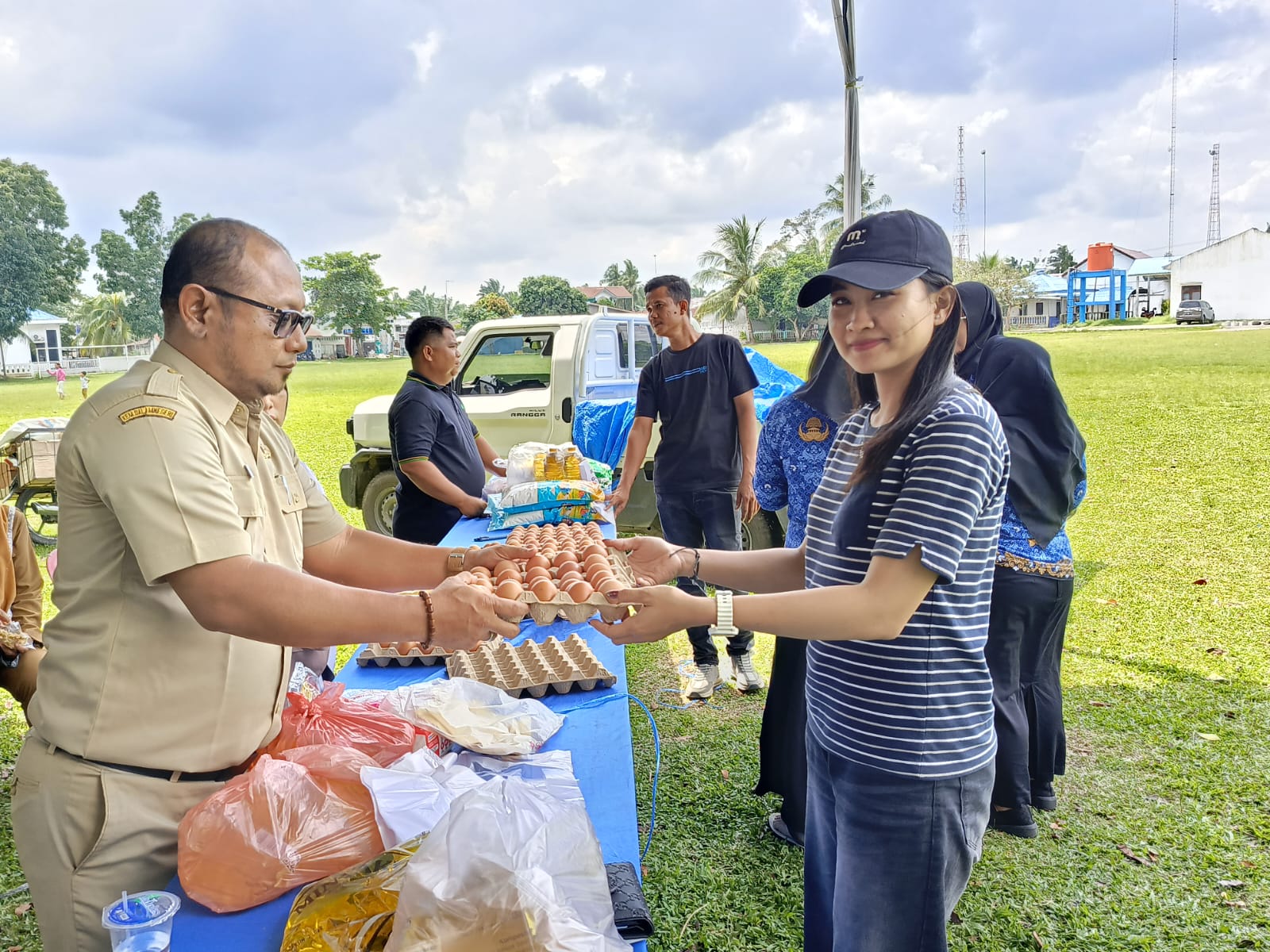 Kadis Distambun) Batubara Ir Susilistiawati Ritonga Msi melalui Kabid Ketapang Hendra Kumara saat melayani warga berbelanja, Senin(22/12) di lapangan bola kaki Limapuluh. (Liberti H Haloho/Sumut Pos)