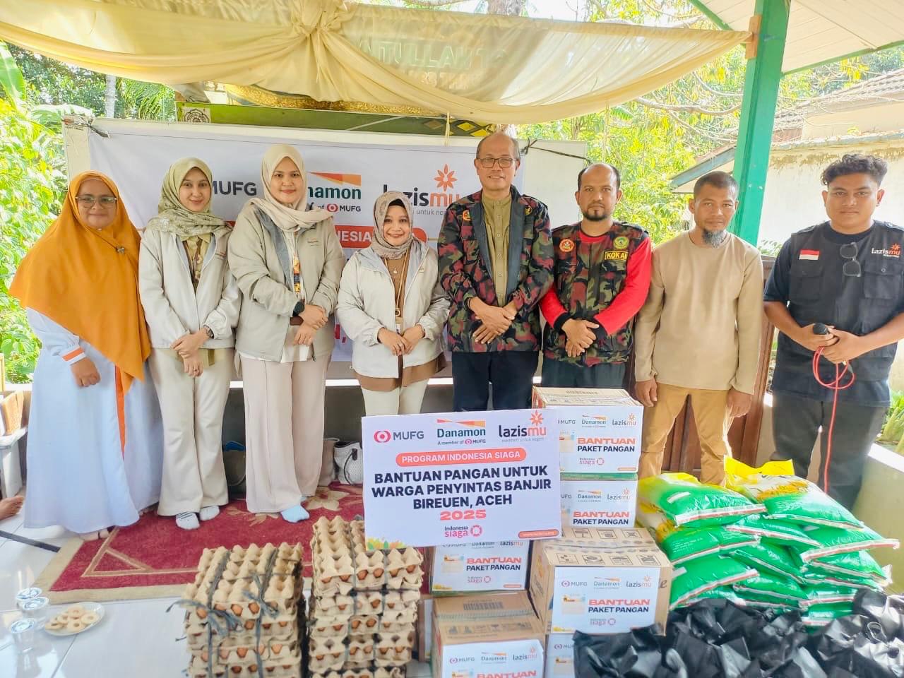 Perwakilan  Manajemen Danamon dan relawan LAZISMU saat menyerahkan bantuan ke warga penyintas bencana di Bireuen. (Foto : Dok Danamon)