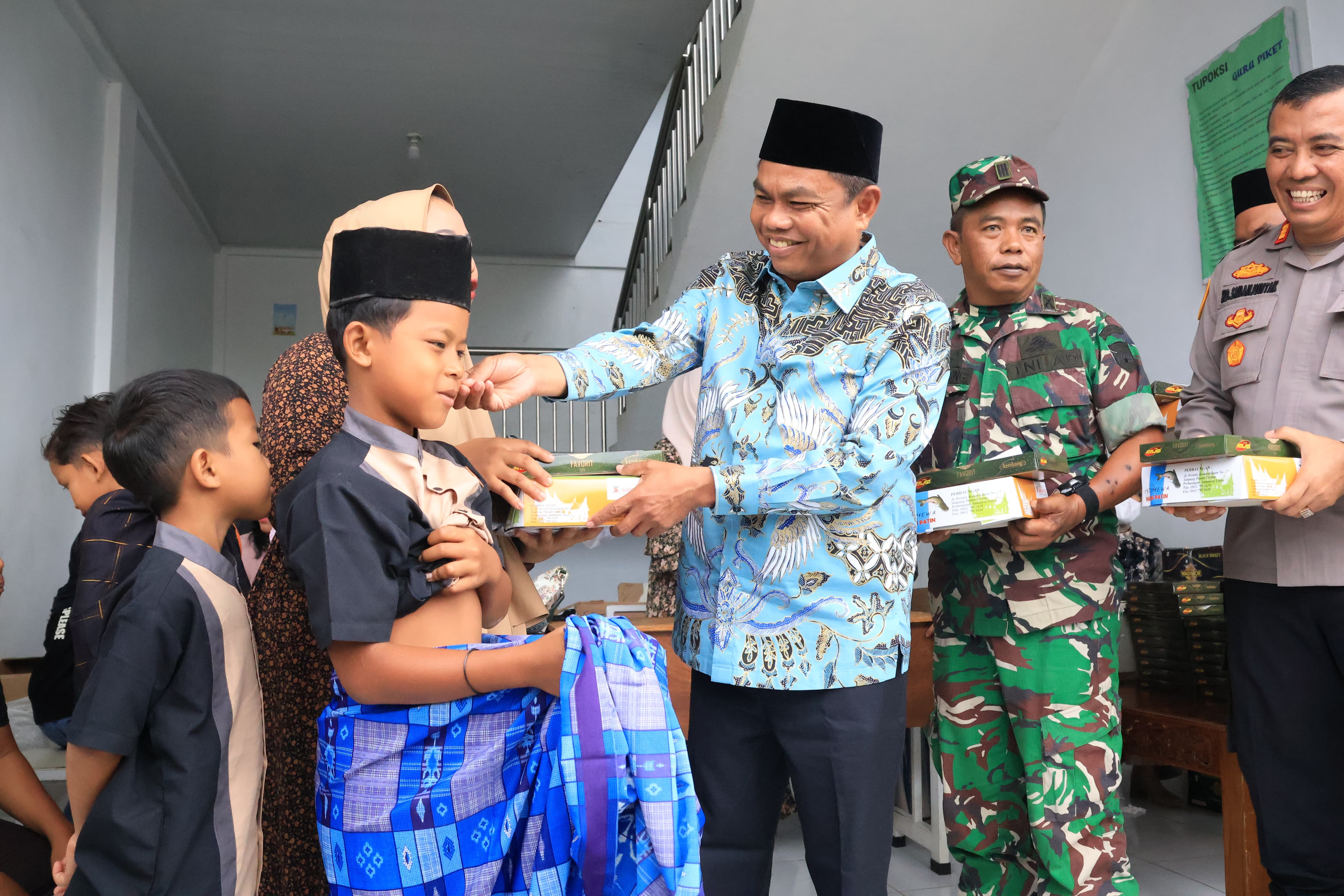 BINGKISAN: Bupati Sergai Darma Wijaya didampingi Wabup Sergai Adlin Tambunan berikan bingkisan  di kegiatan sunnat Massal di Masihul di Dolok Masihul. (Dok: istimewa)