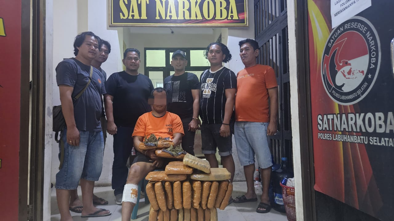 GANJA: Personel Satnarkoba Polres Labusel meringkus pelaku pengedar ganja (duduk) serta 26 kg ganja. (KHAIRUDDIN/SUMUT POS)