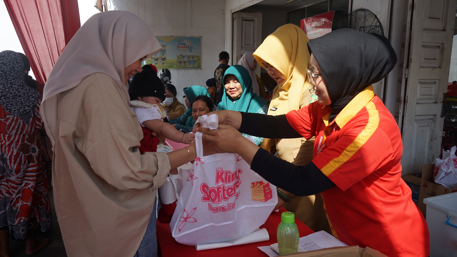 SAHABAT: Karyawan Alfamart Pelajar saat memberikan bingkisan kepada ibu yang hadir acara Alfamart Sahabat Posyandu  diKecamatan Medan Kota, Kota Medan, pada Selasa, (13/1). (Dok: Alfamart)