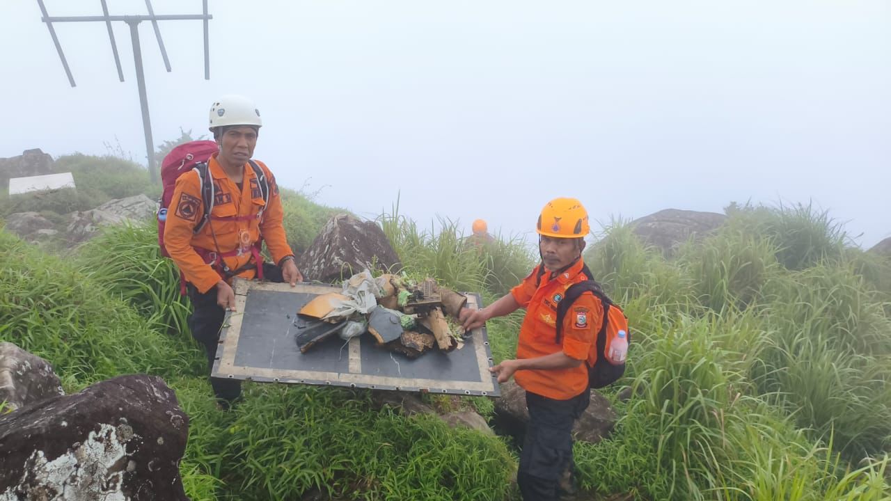 Petugas tim SAR mengevakuasi puing-puing badan pesawat yang jatuh. (JAWAPOS)