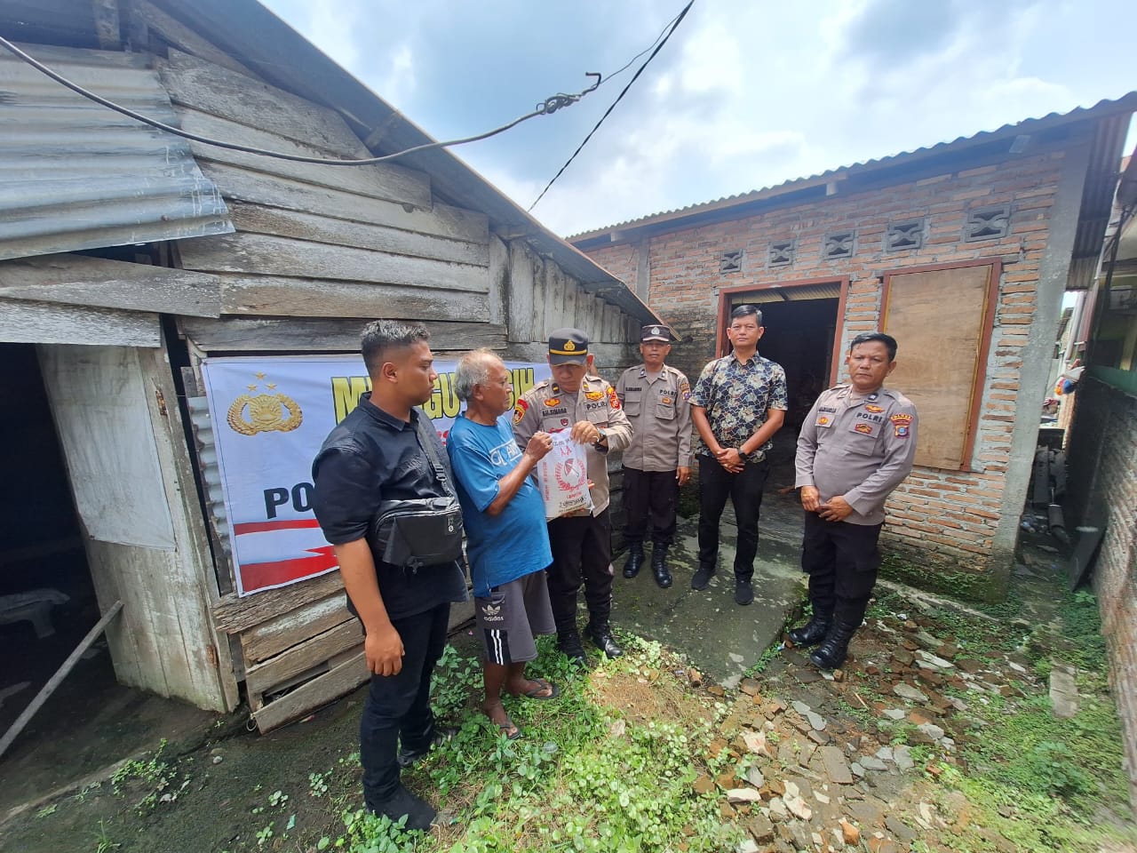 Kapolsek Datuk Bandar, AKP Jh. Turnip, SE bersama personel memberikan bantuan sembako kepada warga tak mampu. (YUNA/SUMUT POS)