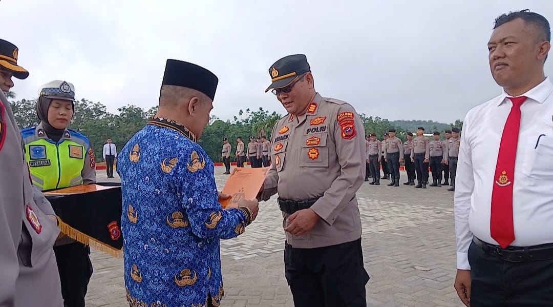 Wabup Labusel,  Syahdian Purba Siboromenyerahkan pigama penghargaan kepada personel Polri yang berkontribusi menjaga kamtibmas. (KHAIRUDDIN/SUMUT POS
