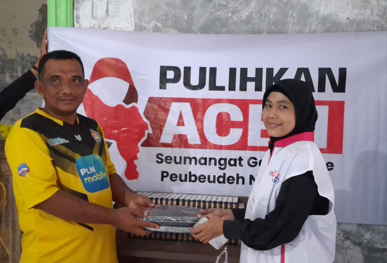 Koordinator AQL Wakaf Quran Nurul Haqqi (kanan) menyerahkan donasi berupa perlengkapan shalat dan wakaf Al-Quran di Masjid Al Mukmin Desa Kebun Tanah Terban, Karang Baru, Aceh Tamiang, Senin (19/1/202