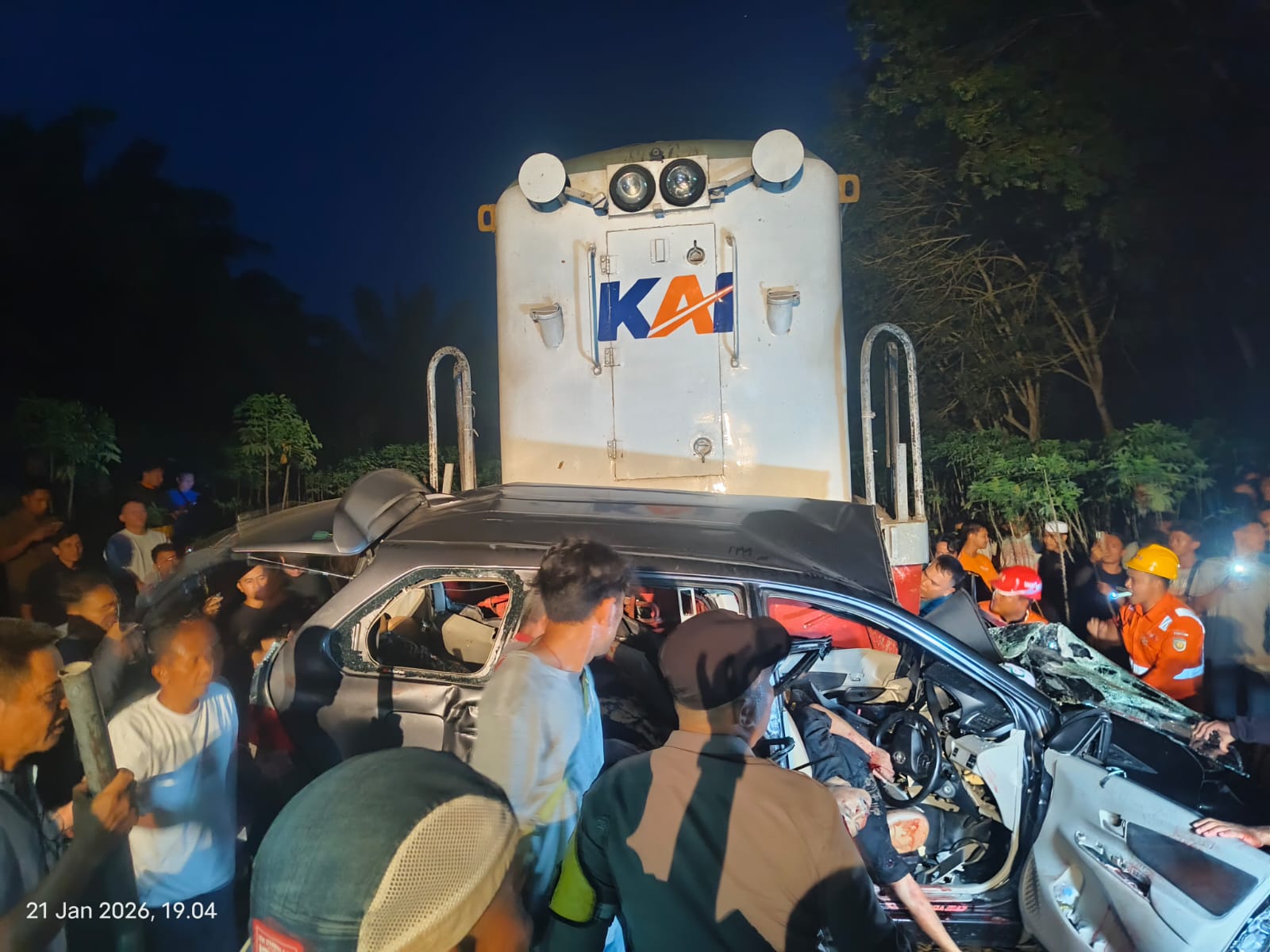 Warga berusaha mengevakuasi korban dari dalam mobil Avanza usai ditabrak kerata api di perlintasan tanpa plang di Tebingtinggi. (Azan Purba/Sumut Pos)