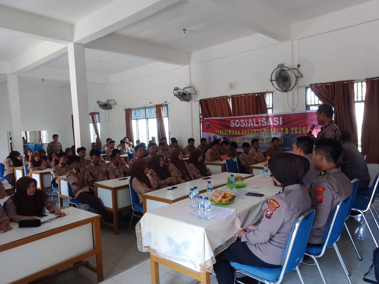 Bhabinkamtibmas Polsek Padang Hulu bersama Tim Bag SDM Polres Tebing Tinggi saat menyampaikan pesan kamtibmas dan sosialisasi penerimaan Bintara Polri Tahun 2026 kepada siswa SMAN 4 Tebing Tinggi.