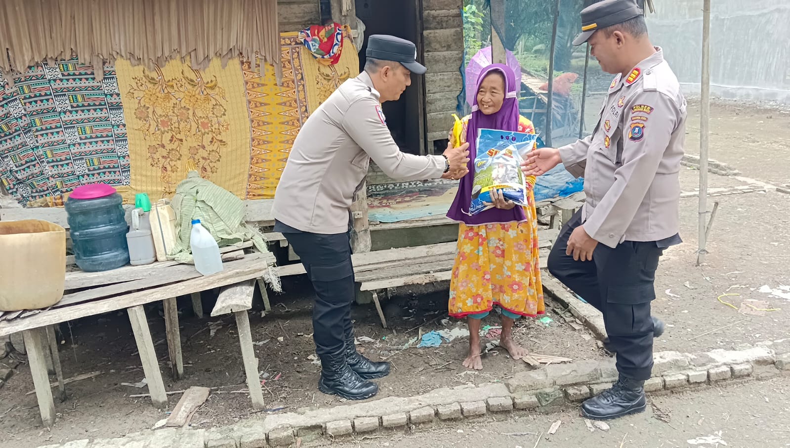 Perssonel Polsek Panai Tengah membagikan bantuan sosial berupa paket sembako kepada masyarakat kurang mampu dalam kegiatan Jumat Berkah (Fajar/Sumut Pos)