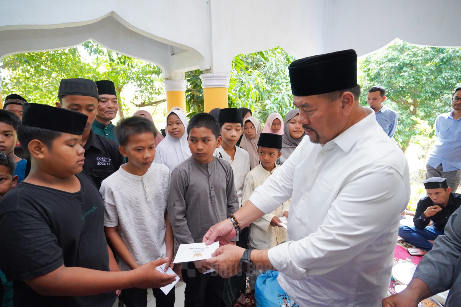 Bupati Batubara H. Baharuddin Siagian, S.H., M.Si sat menyerahkan santunan kepada 100 anak yatim saat Dzikir dan Doa Bersama. (KOMINFO BATUBARA/SUMUT POS)