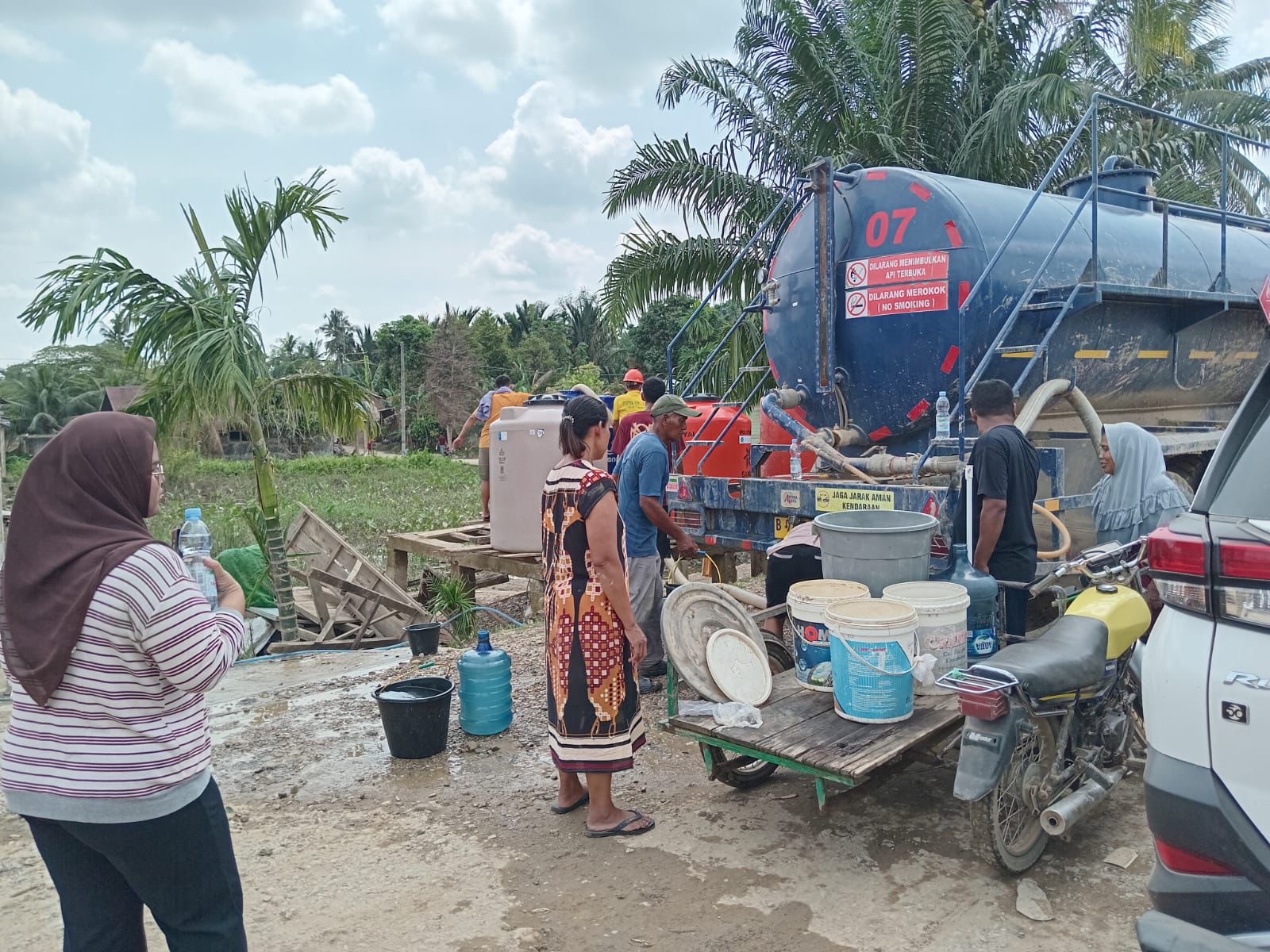 AIR: Warga menampung air bersih yang disediakan oleh Pertamina EP Rantau Field untuk warga Aceh Tamiang. (Dok: PHR Zona 1)