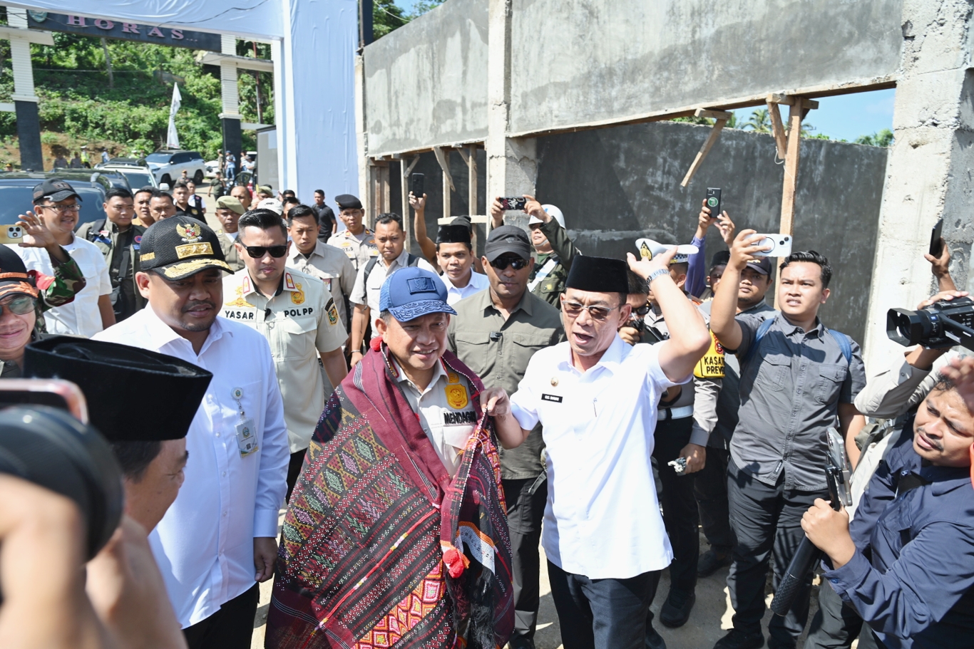 SIMBOLIS: Gubsu Bobby Afif Nasution mendampingi Menteri Dalam Negeri Tito Karnavian, meresmikan Huntara dan penyerahan simbolis bantuan dana tunggu hunian kepada korban bencana banjir dan longsor.