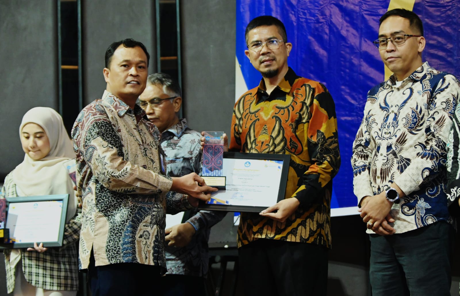 PENGHARGAAN: Ketua STMIK Kaputama Binjai Relita Buaton (kanan) menerima penghargaan dari LLDikti Wilayah I. (Istimewa/Sumut Pos)