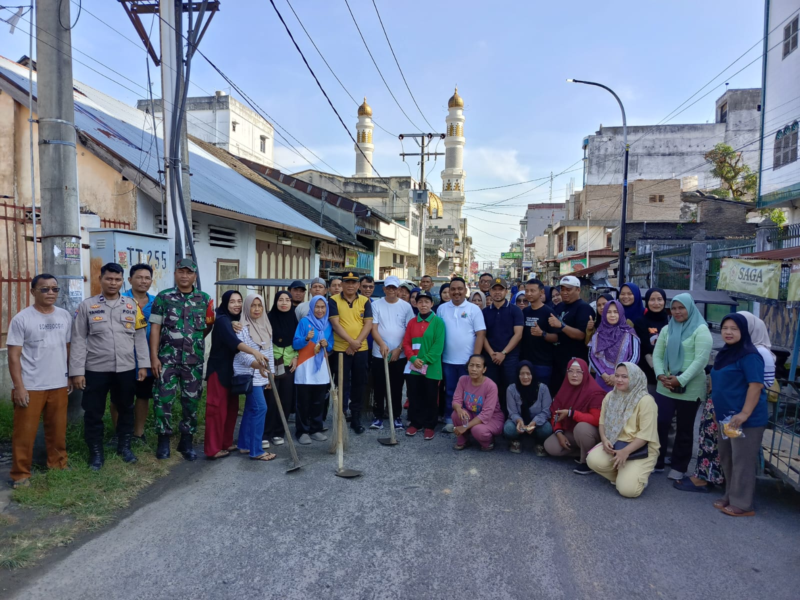 BERSAMA: Camat Tebing Tinggi Kota Henci Siregar bersama Kapolsek Padang Hulu AKP Rudi, dan masyarakat berfoto bersama usai kegiatan gotong royong membersihkan Jalan Benget. (Dok: istimewa)