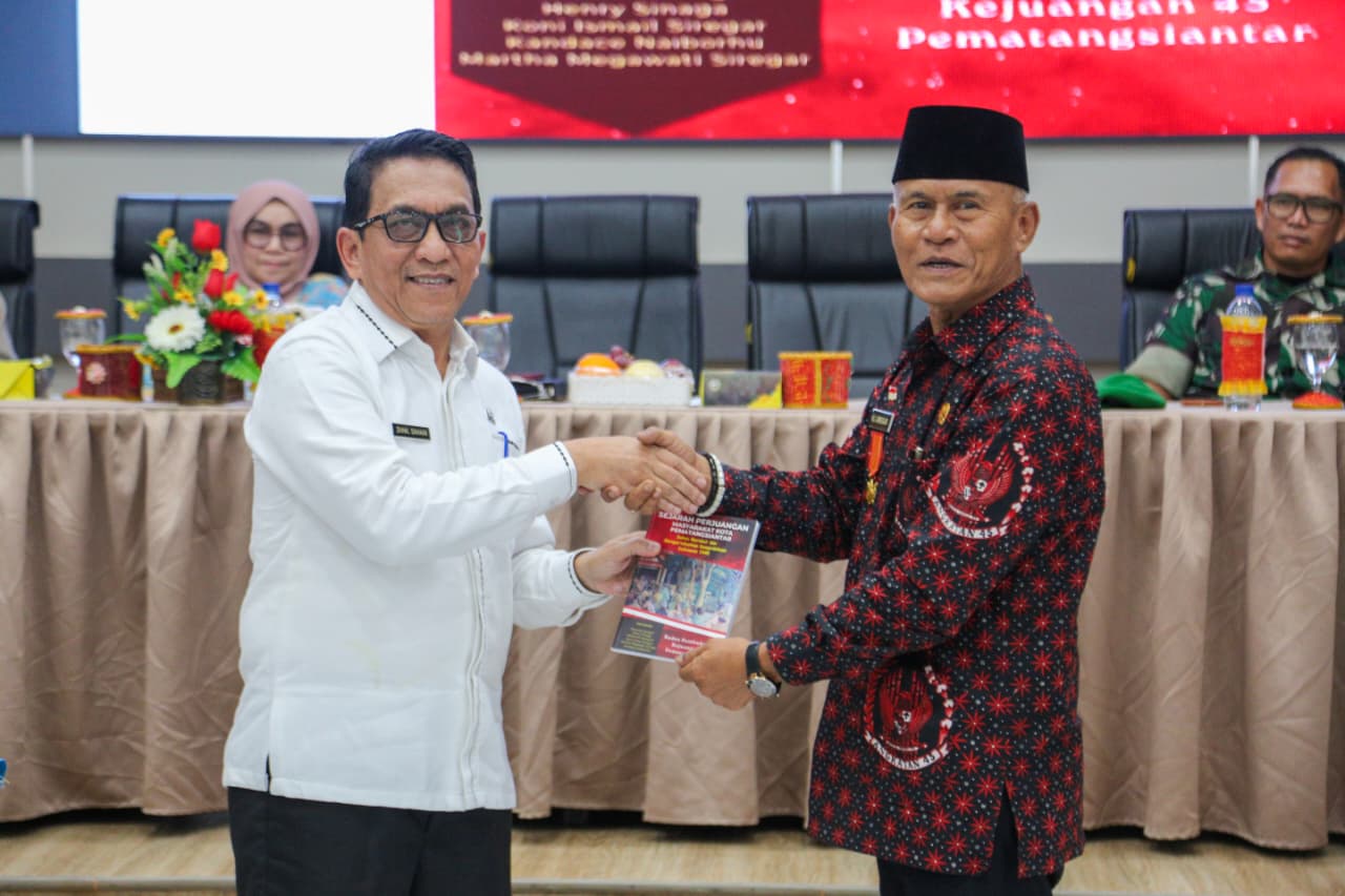 Ketua DHC BPK 45 Kota Pematangsiantar Drs Koni Siregar menyerahkan foto kepada Zainal Siahaan. (ISTIMEWA/SUMUT POS)