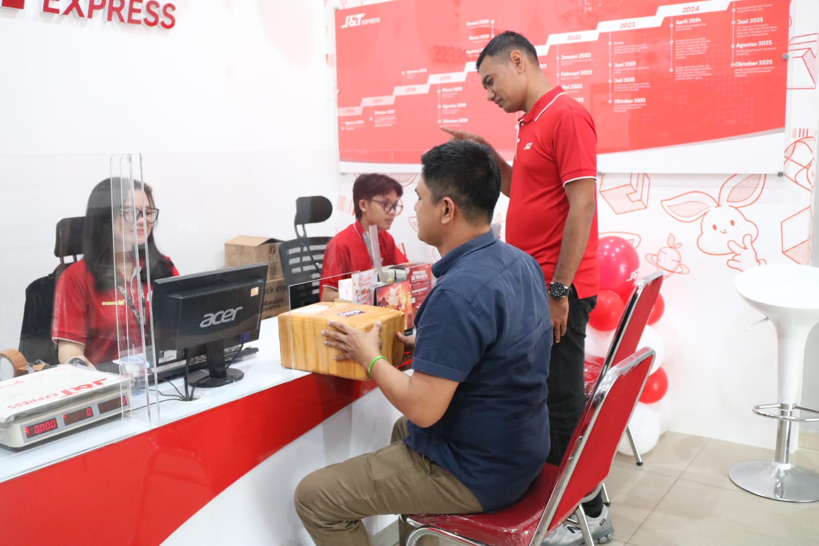 LAYANI: Karyawan J&T Express sedang melayani pelanggan ketika melakukan pengiriman paket di Drop Point Signature Medan. (ISTIMEWA/SUMUT POS)