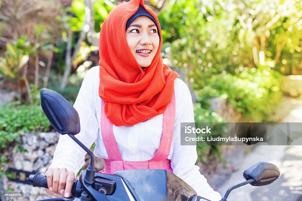 ILUSTRASI: Seorang wanita berhijab mengendarai sepeda motor.