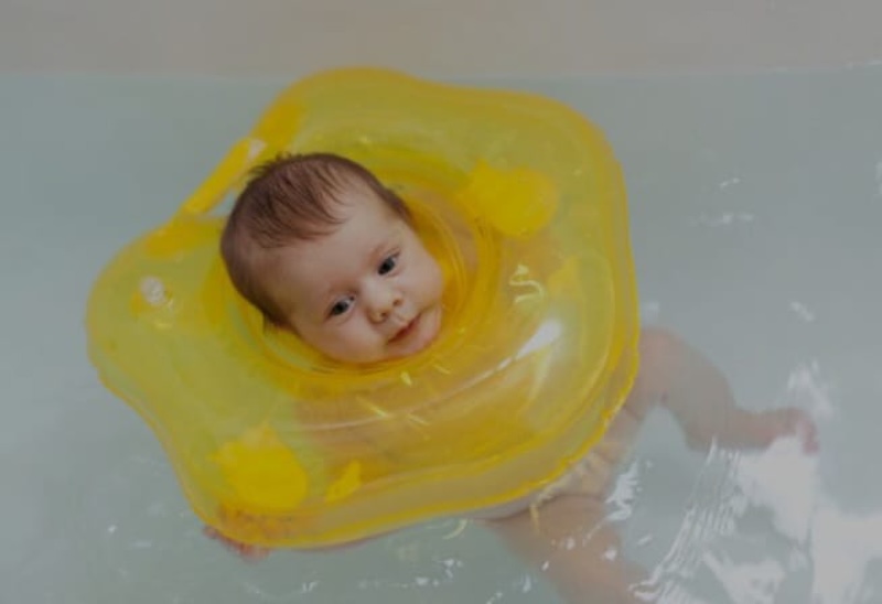 ilustrasi, seorang bayi berenang dengan memakai pelampung air di leher. (freepik.com)