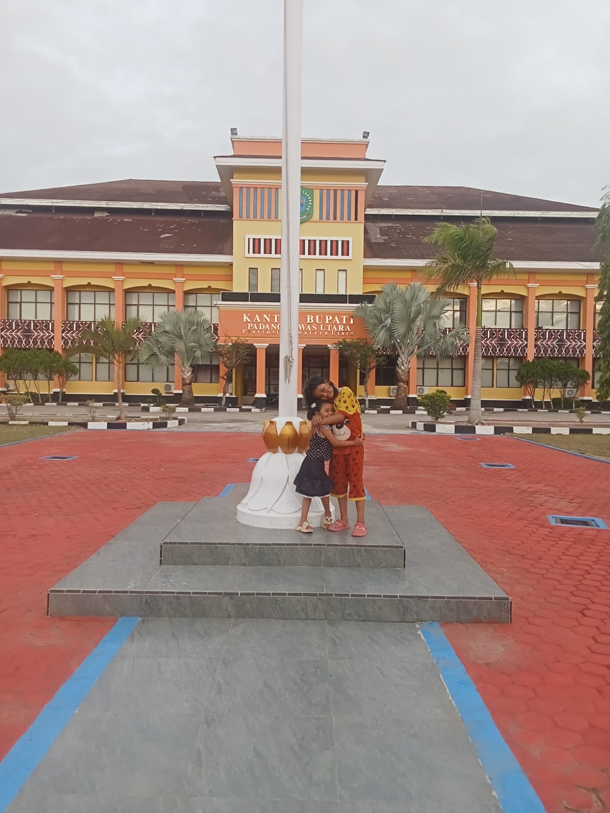 LIBURAN: Kakak beradik menikmati liburan Imlek dan sambut bulan suci Ramadan 1447 H di komplek perkantoran Bupati Paluta. (MITRA HARAHAP/SUMUT POS)