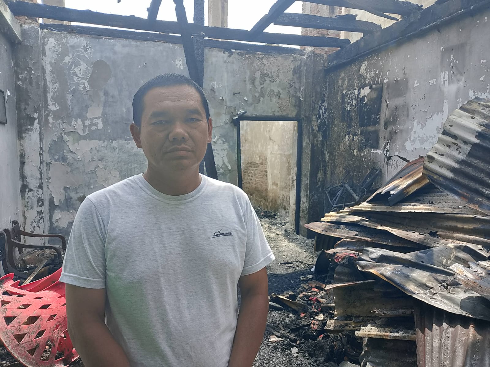 Ramadhan, korban kebakaran Pajak Pekong di Medan Labuhan berdiri di antar puing- puing sisa kebakaran. (Dok: istimewa)