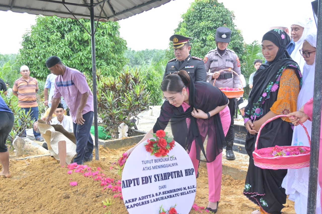 BUNGA: Pelayat saat menaburkan bunga ke makam Aiptu Edy Syahputra Harahap yang meninggal karena sakit. (Dok: istimewa)