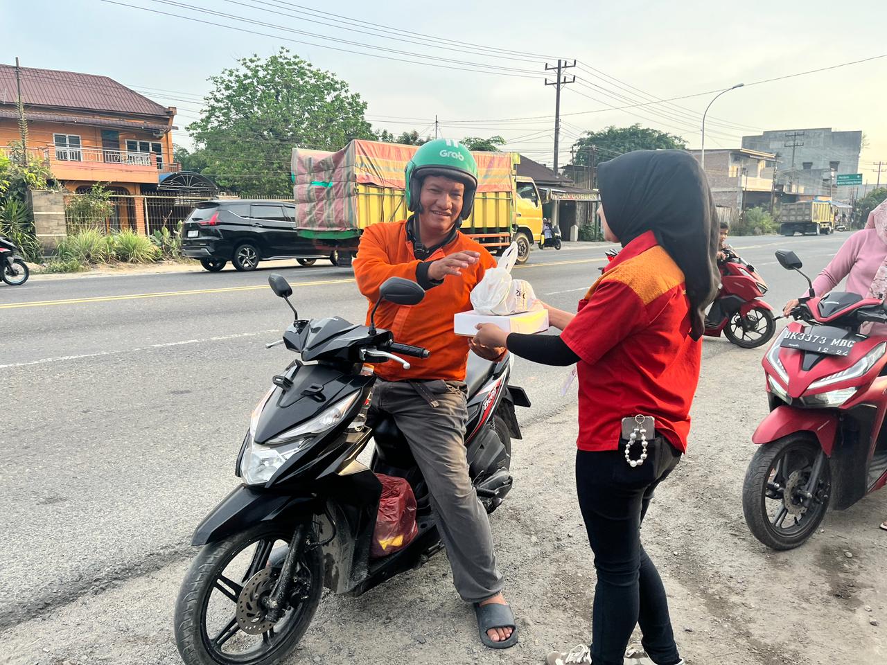 BUKA: Karyawan Alfamart saat memberikan makanan berbuka puasa kepada driver ojek online. (Dok: Alfamart)