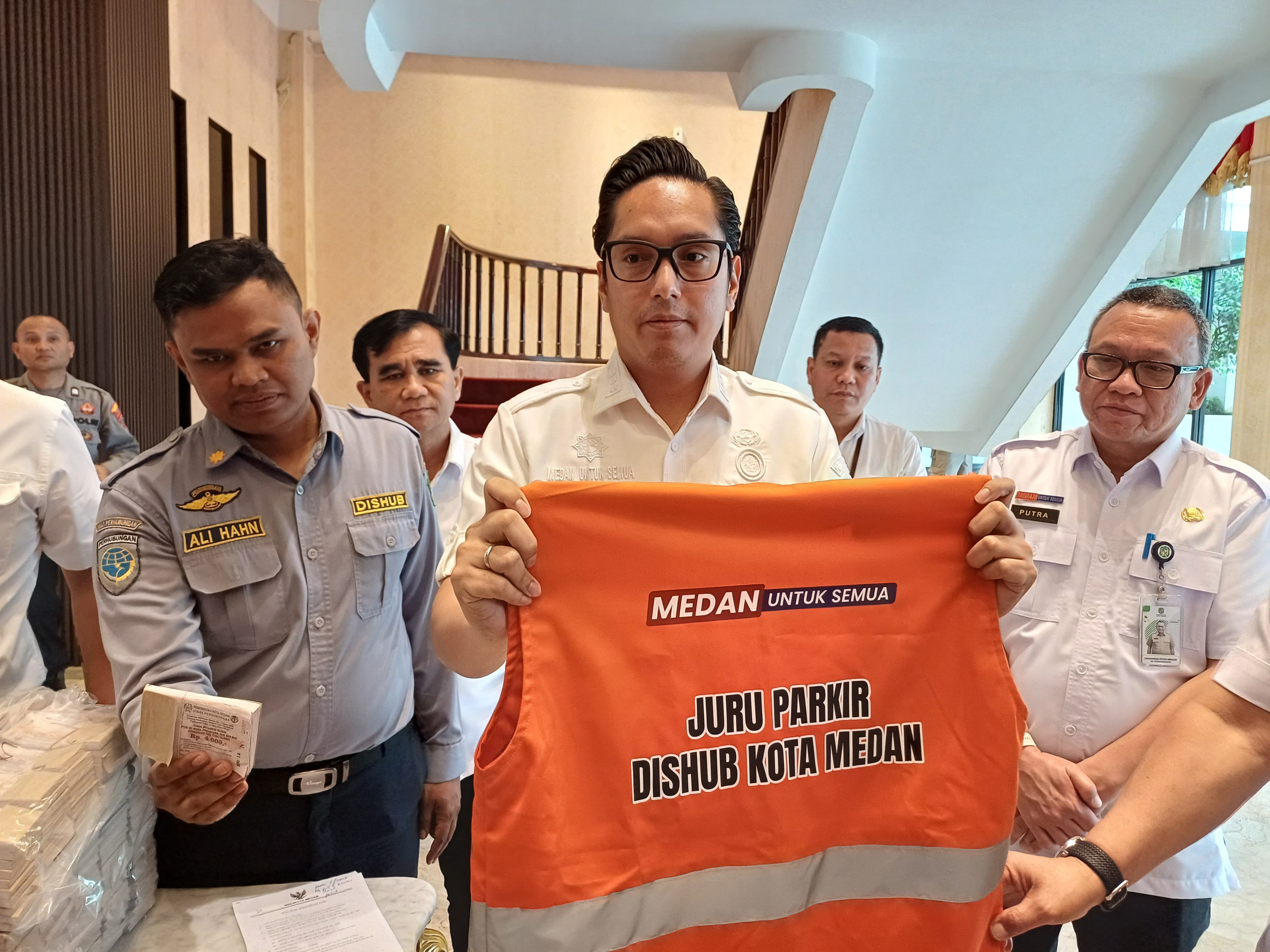 JUKIR: Wali Kota Medan, Rico Tri Putra Bayu Waas menunjukkan seragam jukir dan karcis parkir sesuai tarif terbaru. (Dok: Markus Pasaribu/Sumut Pos)   