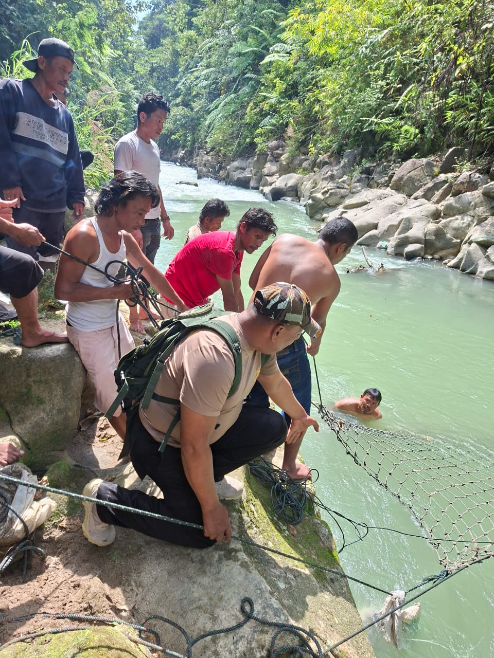 Tim sedang memasang jaring dialiran Sungai Lae Simbelin, Kecamatan Silima Pungga-Pungga dalam upaya pencarian, Ferry Sinaga (12) yang hanyut. (dok.Camat Silima Pungga-Pungga)/Sumut Pos).
