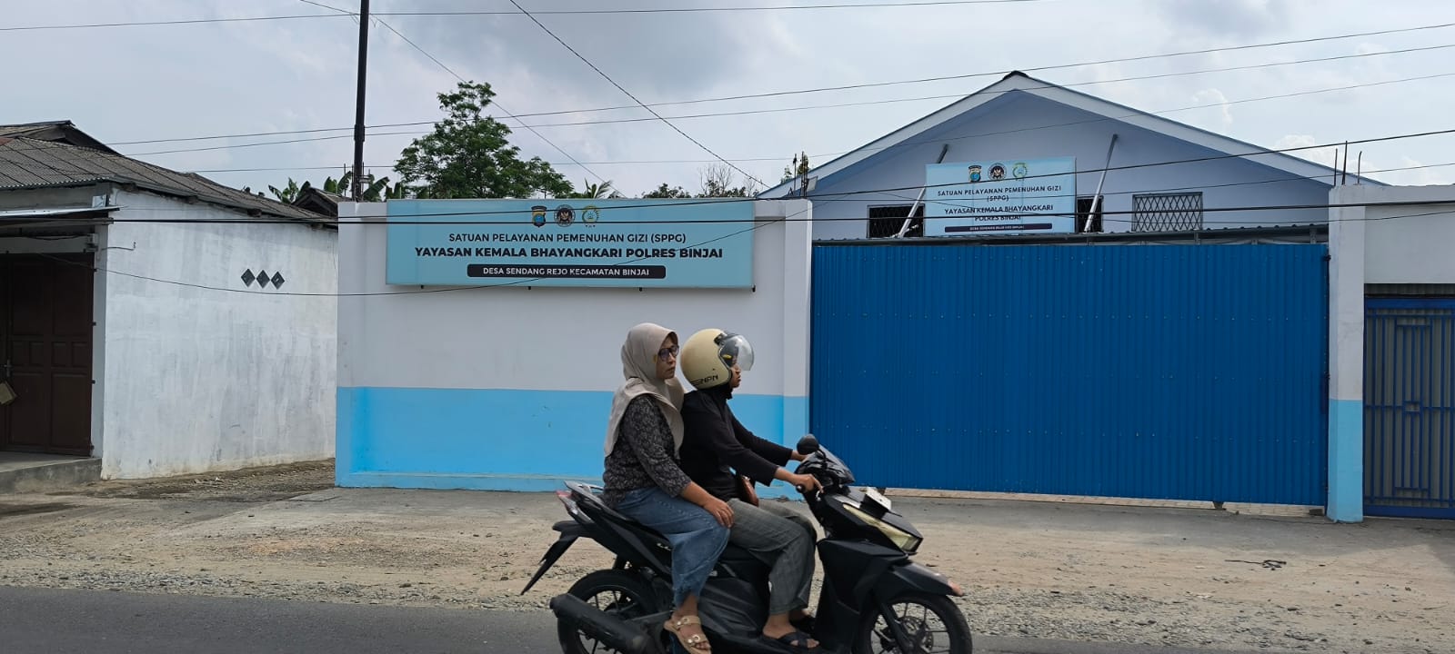  Pengendara sepeda motor saat melintas di depan SPPG Yayasan Kemala Bhayangkari Polres Binjai yang dibekukan sementara operasionalnya. (Teddy Akbari/Sumut Pos)