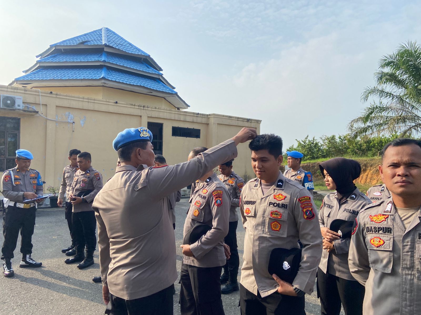 Petugas Sipropam Polres Labusel memotong rambut personel yang panjang. (ISTIMEWA/SUMUT POS)