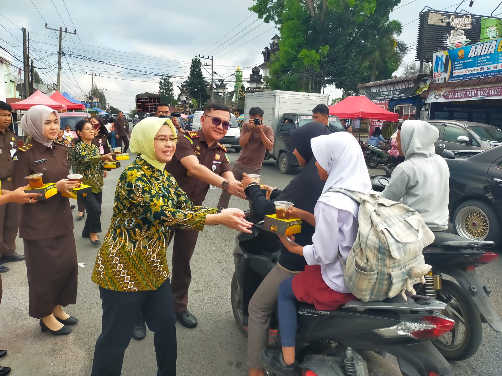 Kajari  Dairi, Bima Yudha bersama Ketua Ikatan Adyaksa Dharmakarini (IAD), Tuti Bima membagikan menu berbuka puasa kepada pengendara melintas didepan Kantor Kejaksaan Dairi, Kamis (12/3/2026).