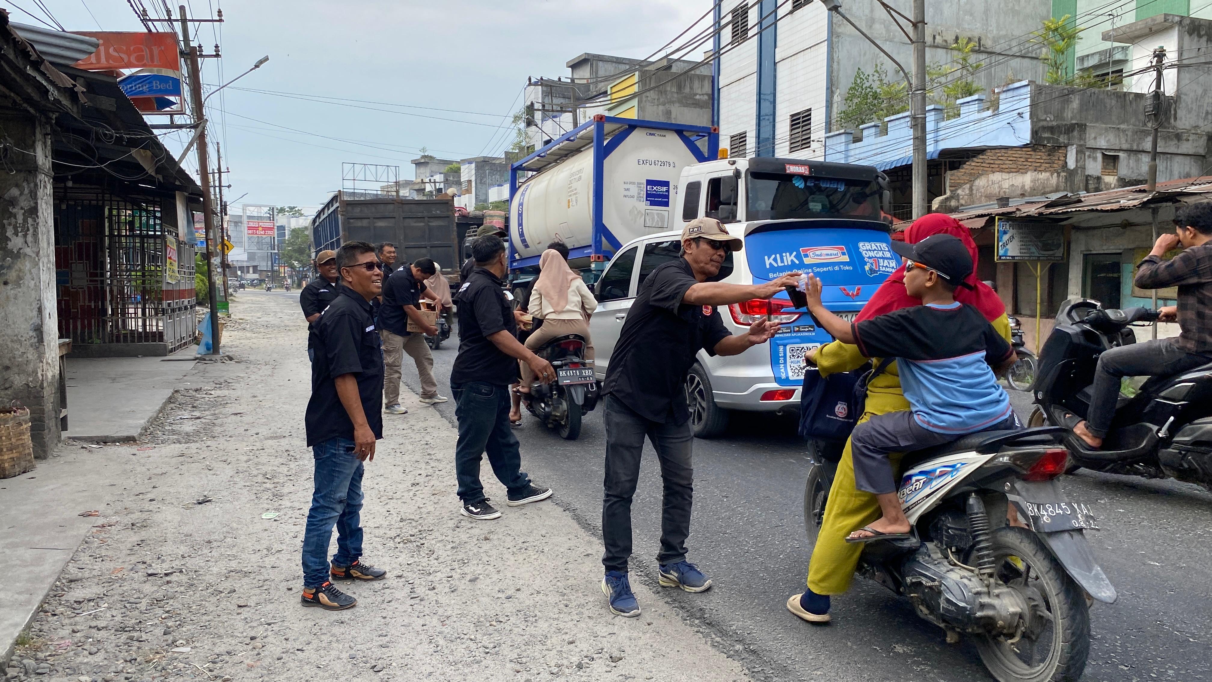 Pengurus dan anggota FORWAKUM Sergai membagikan takjil kepada pengendara yang melintas di Jalinsum Medan&ndash;Tebing Tinggi  di Sei Rampah, Selasa (10/03). ( Fadly/Sumut Pos )
