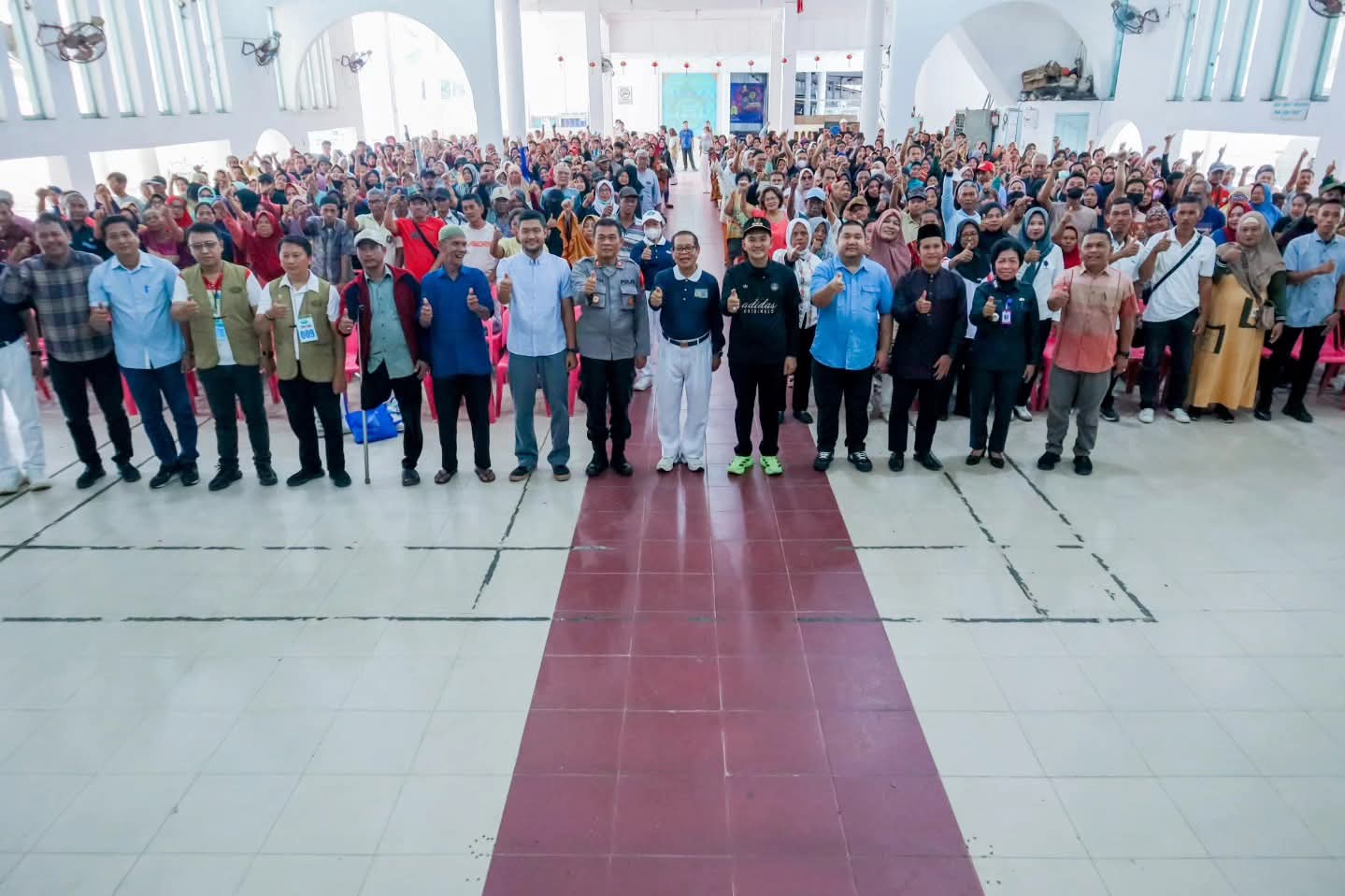 Wali Kota Tebing Tinggi, Iman Irdian Saragih, bersama jajaran dan relawan Yayasan Buddha Tzu Chi berfoto bersama masyarakat penerima bantuan. (Azan Purba/Sumut Pos)