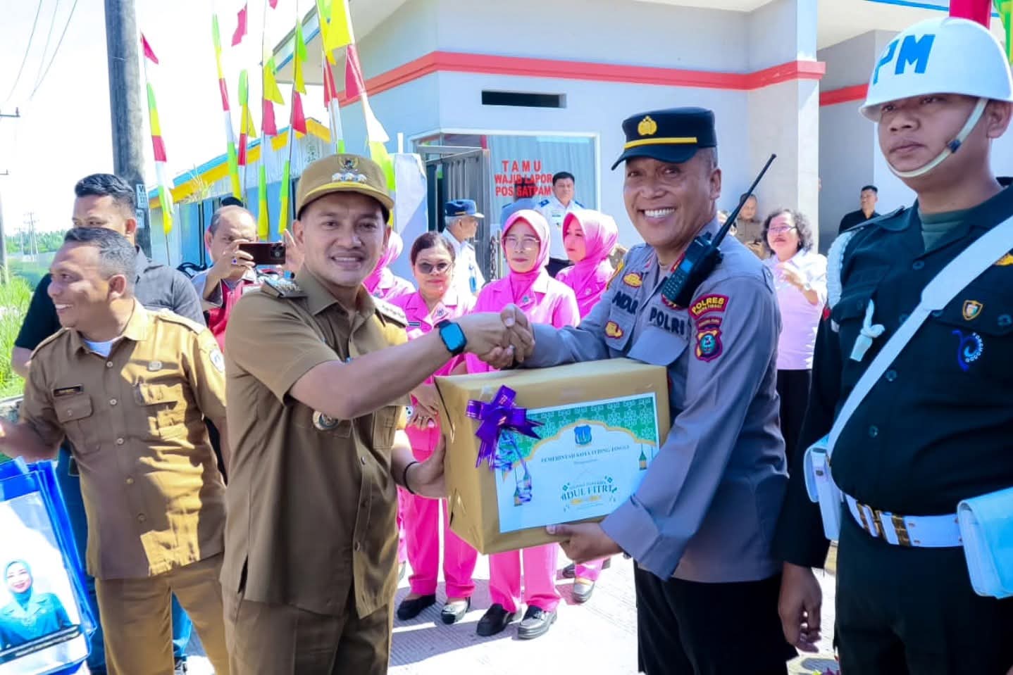 Wali Kota Tebing Tinggi, Iman Irdian Saragih, menyerahkan bingkisan kepada Kapolres Tebing Tinggi, AKBP Rina Frillya, saat meninjau Pos Pelayanan Operasi Ketupat Toba 2026 di Kota Tebing Tinggi,