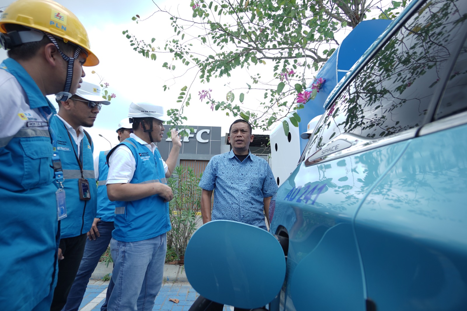 General Manager PLN UID Sumut saat berbincang dengan pengemudi taksi mobil listrik yang sedang melakukan pengisian daya di SPKLU Kualanamu (19/3) (ISTIMEWA/SUMUT POS)