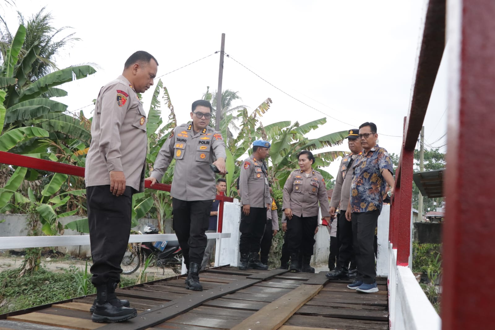 CEK: Personel Polres Serdang Bedagai bersama tim Polda Sumatera Utara melakukan pengecekan kondisi jembatan penghubung Dusun II dan III di Desa Liberia, Teluk Mengkudu, Sergai. (Dok: Fadli/Sumut Pos)