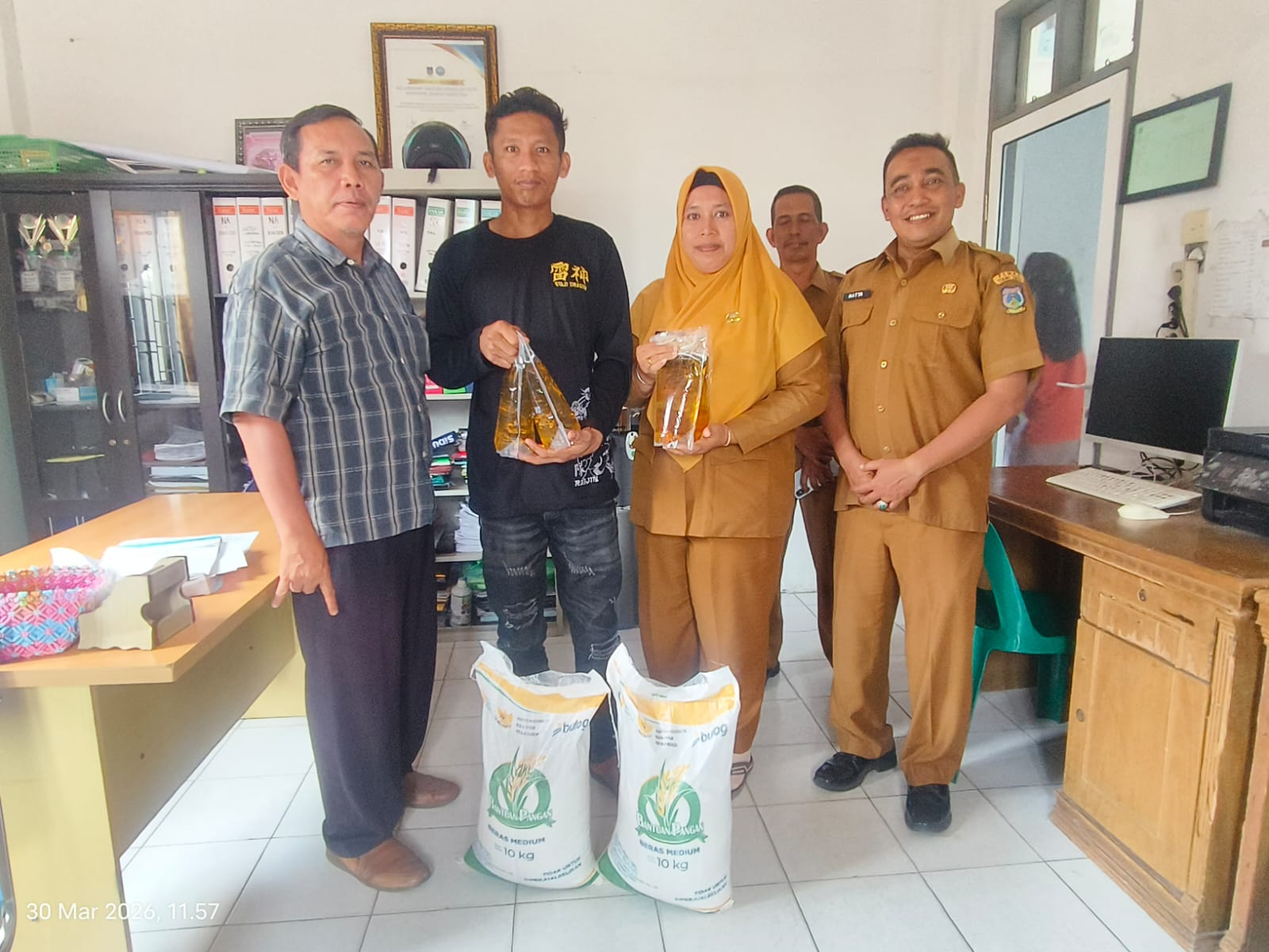 Lurah Eka Sapitri, kasi terantib kecamatan Hatta,Dan jajaran kelurahan penyerahan   sembako Bantuan sosial kepada Heri Bima Utami Purba  di kantor Lurah Tanjung Marulak Hilir. (Azan Purba/Sumut Pos)