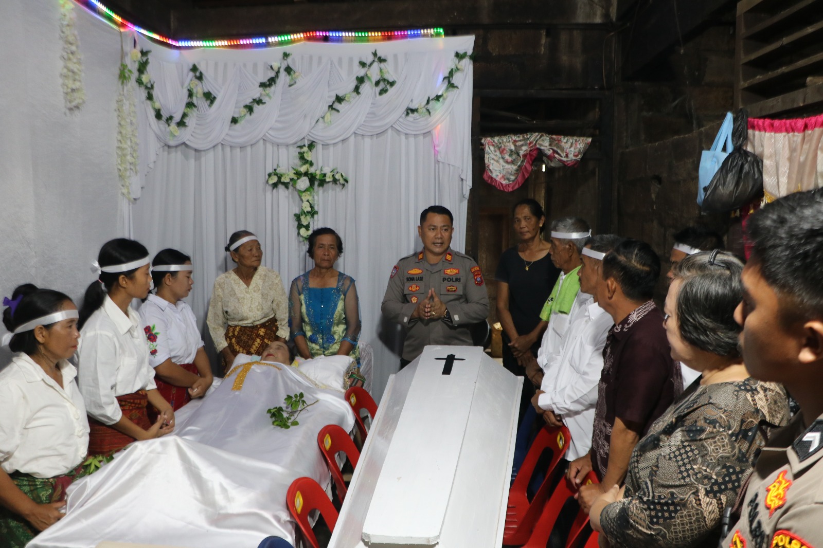 Kasat Binmas Polres Nisel, AKP Sonahami Lase, SH saat menyerahkan peti kepada keluarga almarhum yang berduka. (ERIUSMAN/SUMUT POS)