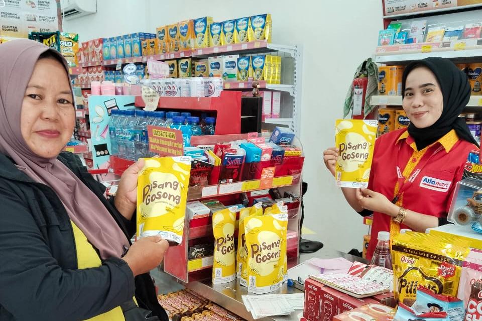 Tuminem saat menunjukkan produk Keripik Pisang Gosong di Alfamart. (Dok: Alfamart)