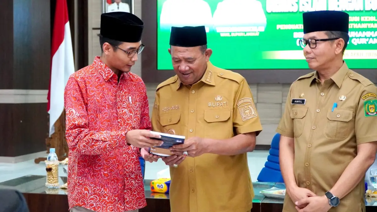 
Bupati Langkat, Syah Afandin saat melihat Buku Qur’anisasi yang diserahkan Dr Muhammad Zuhaili. (Diskominfo Langkat/Sumut Pos)